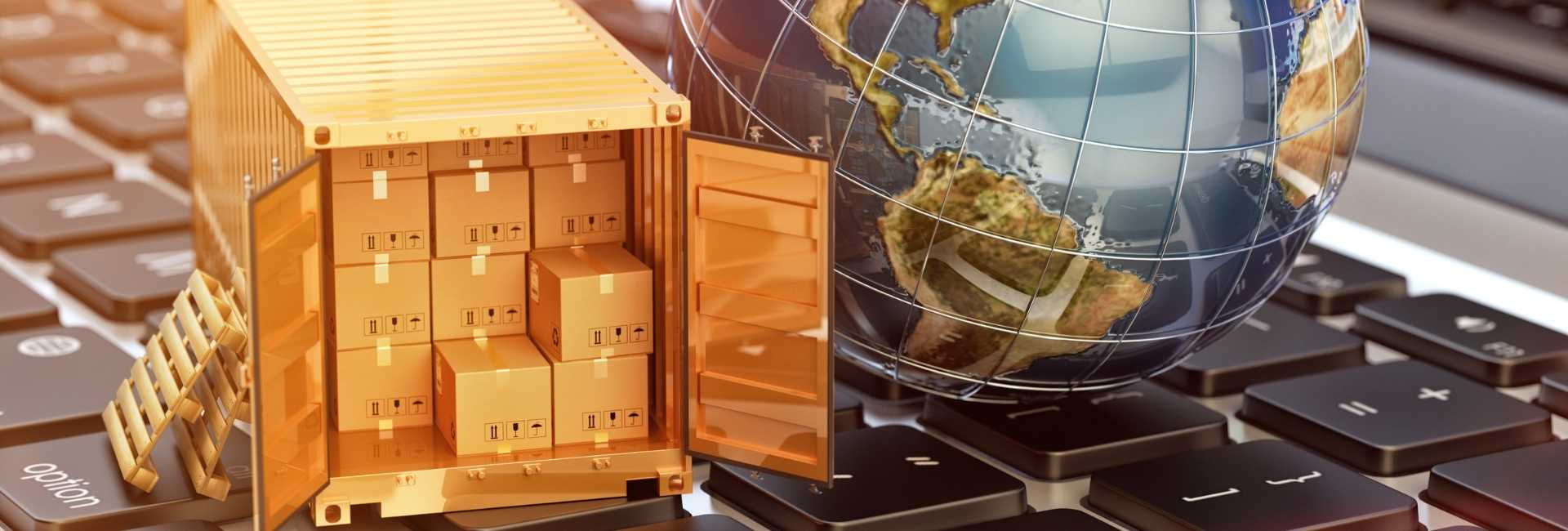 Mini shipping container and globe on keyboard symbolizing global e-commerce.