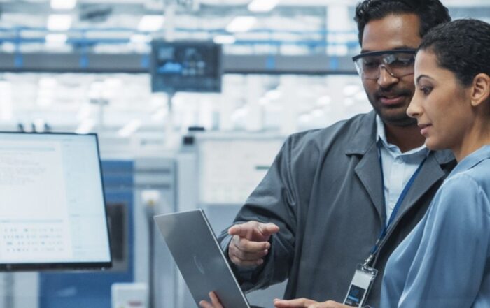 Engineers reviewing performance data on a tablet in a modern industrial facility.