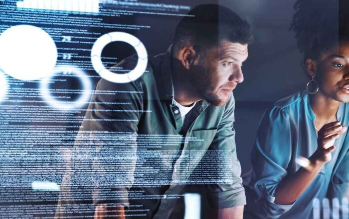 Team analyzing digital data and dashboards on a large screen during a collaborative work session